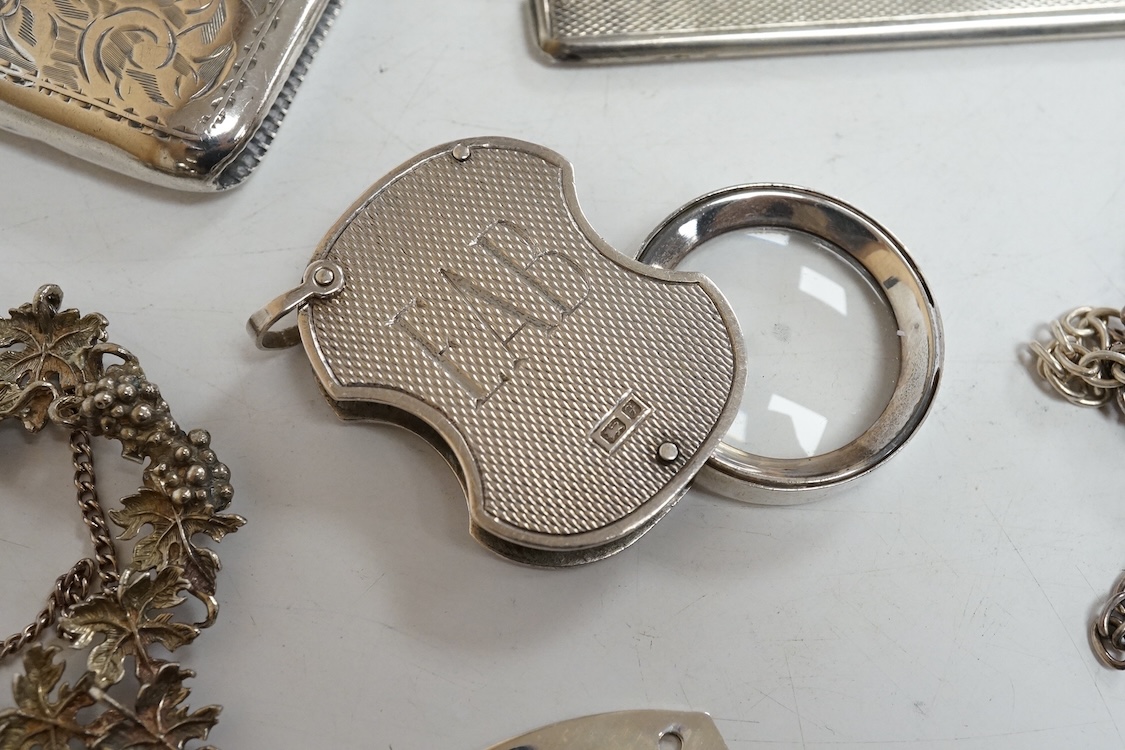 A small group of collectable silver including an Edwardian card case, a set of three modern silver wine labels with applied fruiting vine border, one a.f. London, 1975, a vesta case, travelling comb and folding eye glass